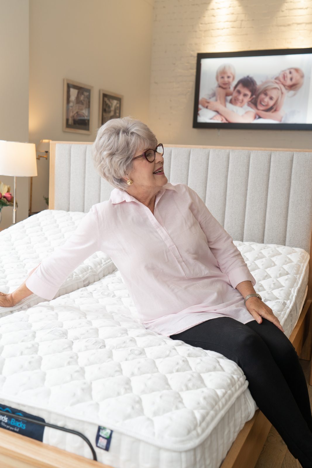 Customer sitting up on an adjustable bed in the showroom