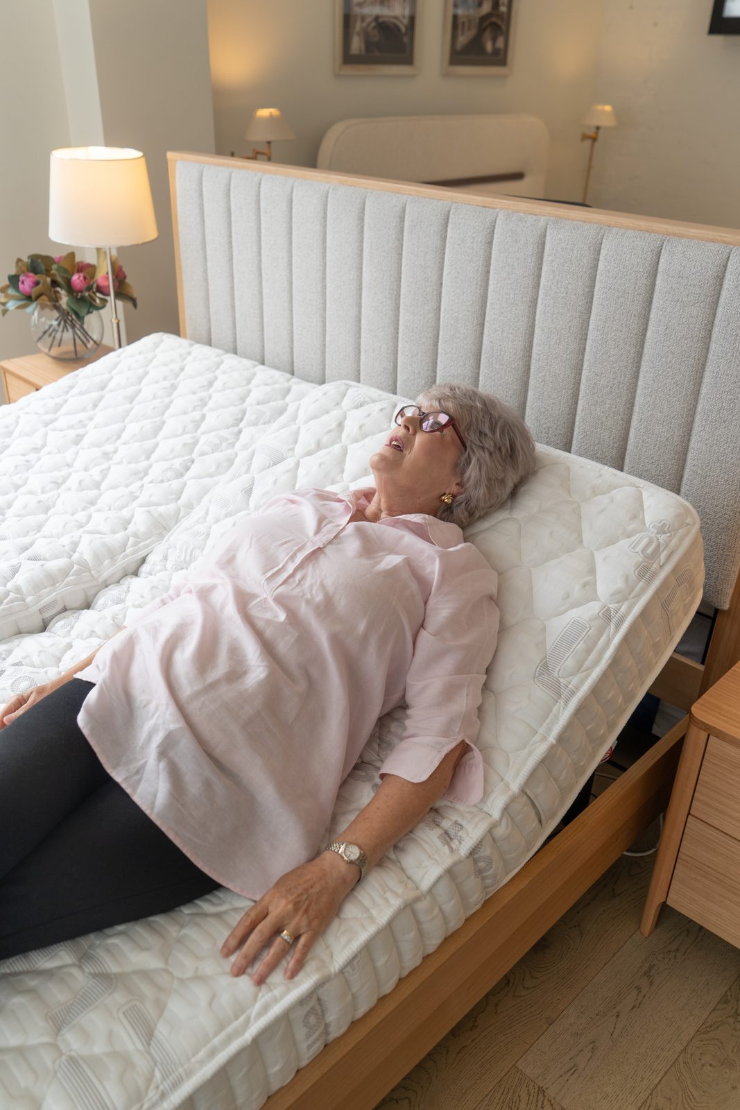 Customer relaxing on an adjustable bed with the head raised